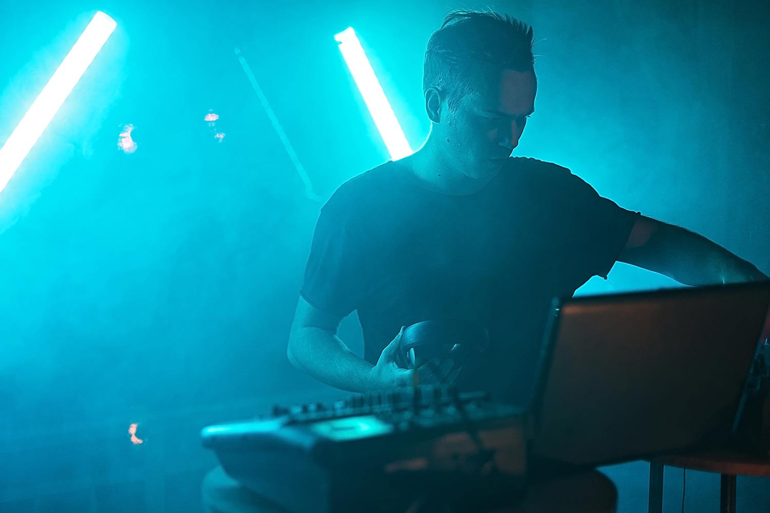 dj holding headphones in a club