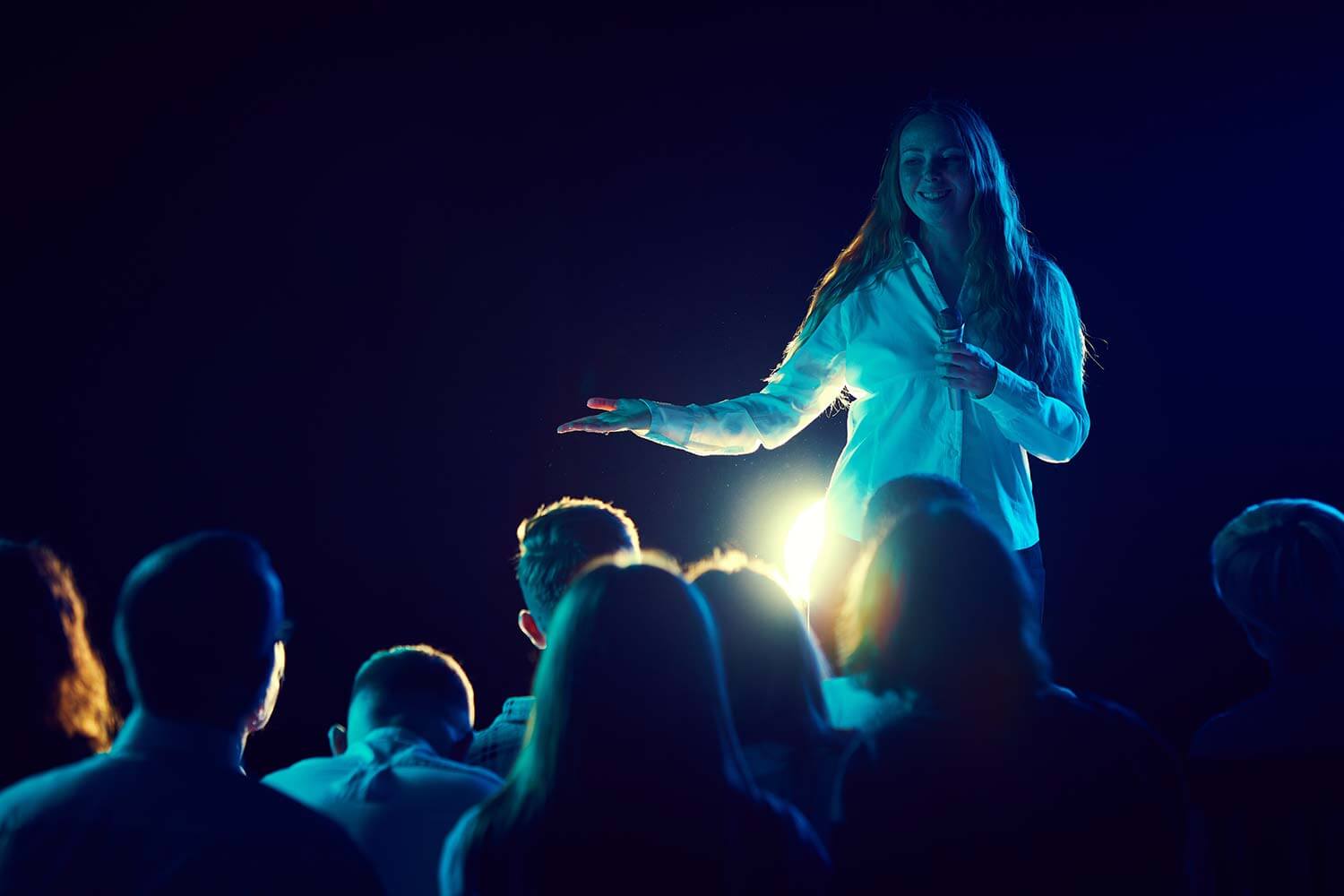 Female comedian performing at a gig